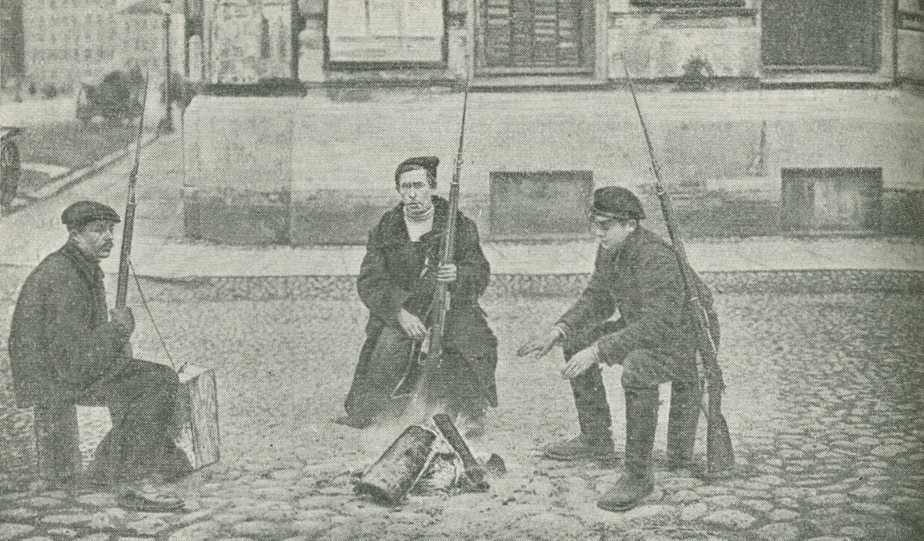 Image of three Red Guards sitting in a street around a small fire
