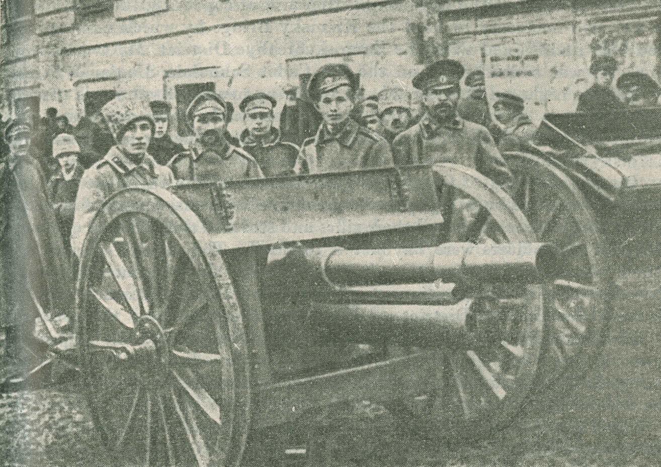 Photograph of soldiers standing behind a piece of artillery